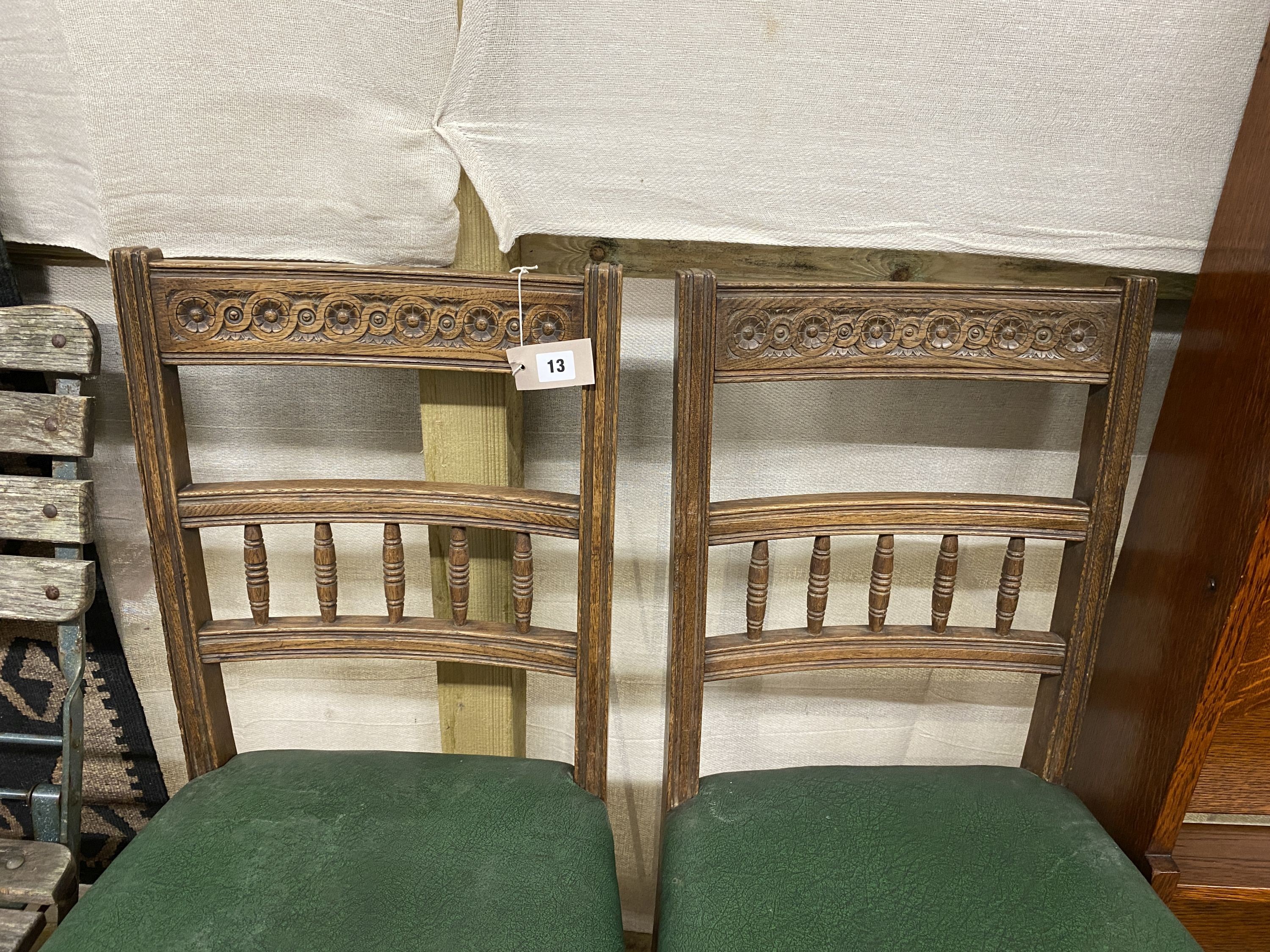 A pair of late Victorian carved oak dining chairs